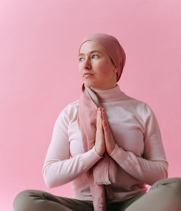 Woman in a graceful yoga pose with pink light accents.